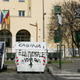 A woman walks past a trash bin defaced with graffiti (translation: “Electoral booth. Vote here”) in Rome.